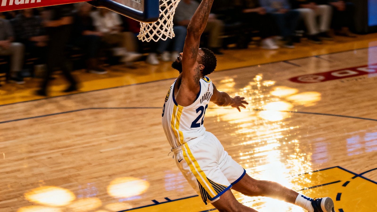 NBA本周十佳球集锦视频缩略图，画面展示一名球员完成高难度扣篮的精彩定格瞬间，篮球与篮筐之间仅差分毫，球员身体在空中完全伸展，球馆灯光在硬木地板上反射出耀眼光斑。